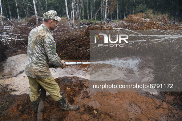 Rescuer extinguishes peat soil fires near the village of Sosnivka in the Kyiv Region, Ukraine September 6, 2022 