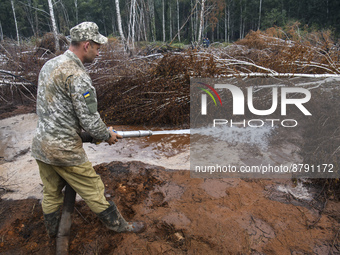 Rescuer extinguishes peat soil fires near the village of Sosnivka in the Kyiv Region, Ukraine September 6, 2022 (