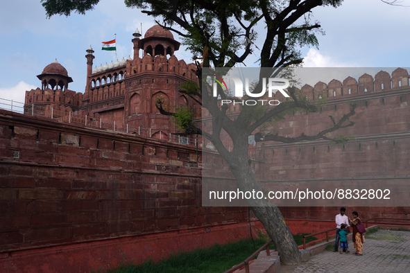 A family visits at the historic Red Fort while the Indian national flag flies half-mast, as India observes one-day state mourning following...