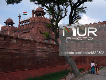 A family visits at the historic Red Fort while the Indian national flag flies half-mast, as India observes one-day state mourning following...