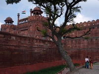 A family visits at the historic Red Fort while the Indian national flag flies half-mast, as India observes one-day state mourning following...