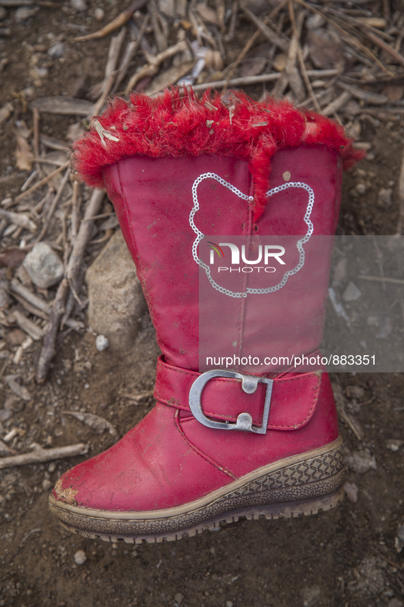 Girls' red pleather and faux fur-lined boot found near Eftalou on the island of Lesbos.  Shoes found on the beaches and around the Greek isl...