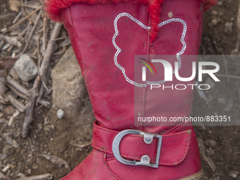 Girls' red pleather and faux fur-lined boot found near Eftalou on the island of Lesbos.  Shoes found on the beaches and around the Greek isl...