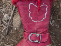 Girls' red pleather and faux fur-lined boot found near Eftalou on the island of Lesbos.  Shoes found on the beaches and around the Greek isl...