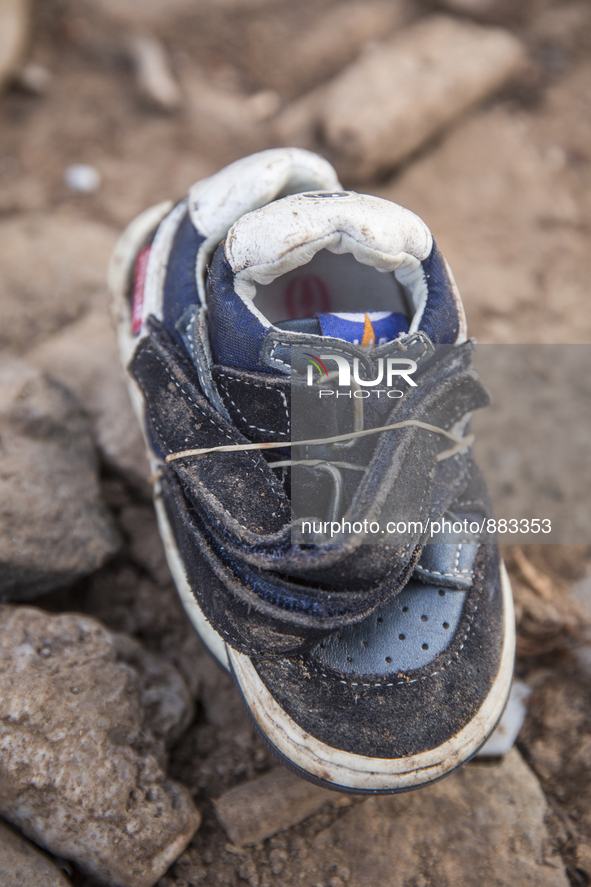 Infant leather and suede sneakers found tied together with elastic bands near Eftalou on the island of Lesbos.  Shoes found on the beaches a...