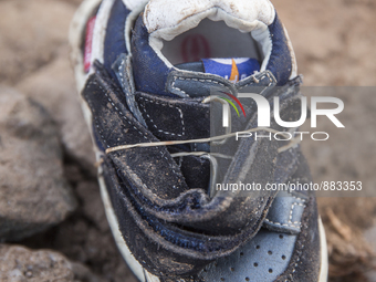 Infant leather and suede sneakers found tied together with elastic bands near Eftalou on the island of Lesbos.  Shoes found on the beaches a...