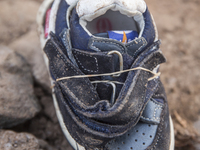 Infant leather and suede sneakers found tied together with elastic bands near Eftalou on the island of Lesbos.  Shoes found on the beaches a...