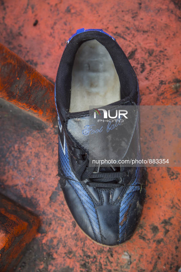 Men's football sneaker found in an abounded boat used by immigrants near Eftalou on the island of Lesbos.  Shoes found on the beaches and ar...