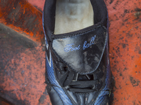 Men's football sneaker found in an abounded boat used by immigrants near Eftalou on the island of Lesbos.  Shoes found on the beaches and ar...