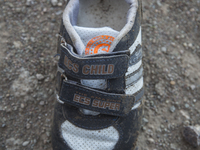 Boys sneaker with velcro closures found near Eftalou on the island of Lesbos.  Shoes found on the beaches and around the Greek island where...