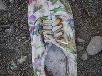 Woman's canvas sneaker with floral pattern found near Eftalou on the island of Lesbos.  Shoes found on the beaches and around the Greek isla...