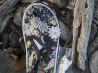 Girl's sneaker with floral designs found near Eftalou on the island of Lesbos.  Shoes found on the beaches and around the Greek island where...