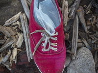 Woman's red canvas with plastic bags inside found near Eftalou on the island of Lesbos.  Shoes found on the beaches and around the Greek isl...