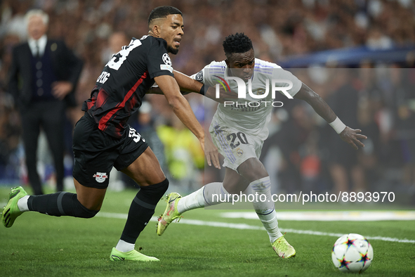 Vinicius Junior left winger of Real Madrid and Brazil and Benjamin Henrichs right-back of RB Leipzig and Germany compete for the ball during...