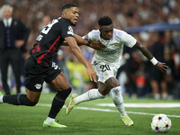 Vinicius Junior left winger of Real Madrid and Brazil and Benjamin Henrichs right-back of RB Leipzig and Germany compete for the ball during...