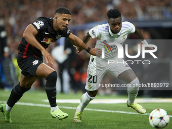 Vinicius Junior left winger of Real Madrid and Brazil and Benjamin Henrichs right-back of RB Leipzig and Germany compete for the ball during...