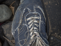 Men's denim sneaker with plaid lining found near Eftalou on the island of Lesbos.  Shoes found on the beaches and around the Greek island wh...