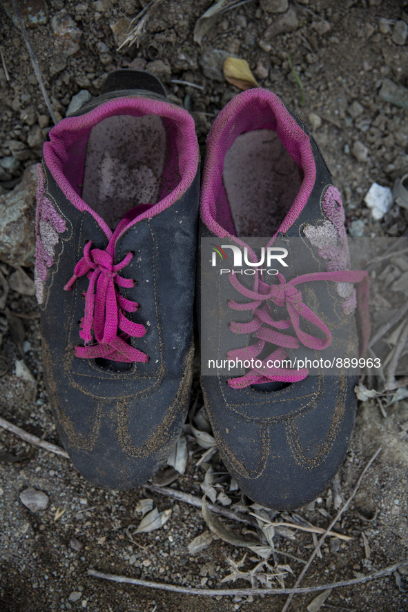 Women's sneakers with pink laces found near Eftalou on the island of Lesbos.  Shoes found on the beaches and around the Greek island where t...