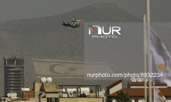 A police helicopter flies over a military parade celebrating the 61st anniversary of Cyprus' independence from British colonial rule, agains...