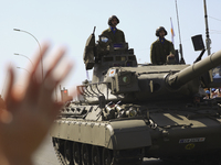 A woman applauds Cypriot soldiers who ride tanks during a military parade to celebrate Independence in Nicosia on the divided island of Cypr...