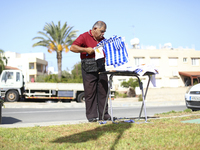 A man sells the national flags of Greece and Cyprus before the start of a military parade to mark the 61st anniversary of the independence o...