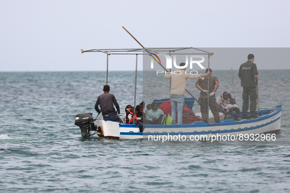 Guard coast agent on a fish boat transferring migrants to another unity to take them to the land. 