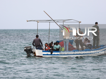 Guard coast agent on a fish boat transferring migrants to another unity to take them to the land. (