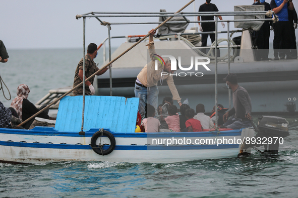 One of the migrants gives water to the kids during the transfer to the unity of the Tunisian guard coast. 