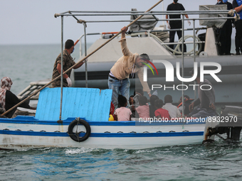 One of the migrants gives water to the kids during the transfer to the unity of the Tunisian guard coast. (