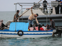 One of the migrants gives water to the kids during the transfer to the unity of the Tunisian guard coast. (