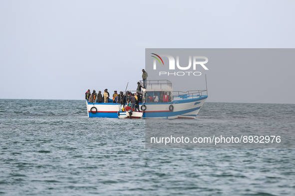 Migrants on small sailboat waiting to transfer  