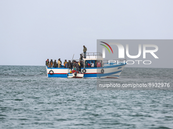 Migrants on small sailboat waiting to transfer  (