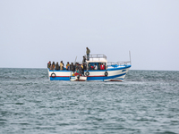 Migrants on small sailboat waiting to transfer  (