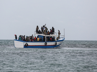 Migrants on small sailboat waiting to transfer  (