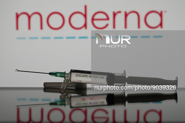 In this photo illustration a covid-19 vaccine is seen with the Moderna logo in the background. (Photo Illustration by Nikos Pekiaridis/NurPh...