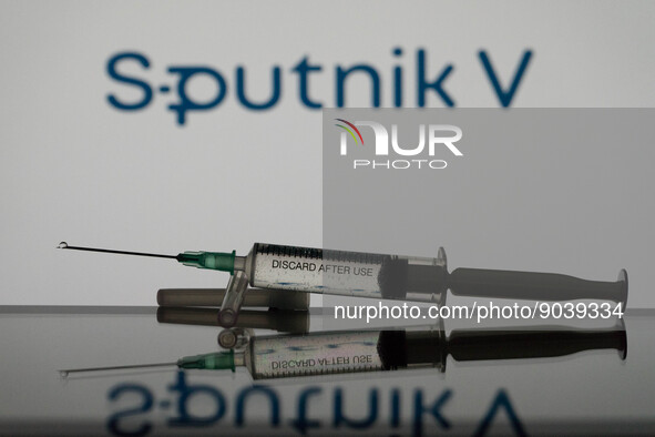 In this photo illustration a covid-19 vaccine is seen with the Sputnik-V logo in the background. (Photo Illustration by Nikos Pekiaridis/Nur...