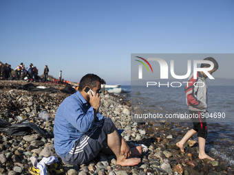 A man makes a call moments after refugees and migrants riding a dinghy reached the shores of the Greek island of Lesbos after crossing the A...