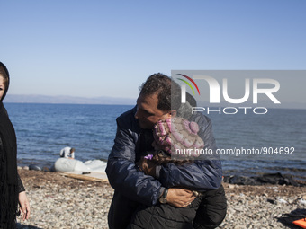 A man from Syria embraces his son as refugees and migrants riding a dinghy reach the shores of the Greek island of Lesbos after crossing the...