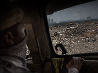 A guard is observing the  west dumping ground sitting inside a waste carrying truck, Dhapa, Kolkata, India. January 20, 2015. *** Go to http...