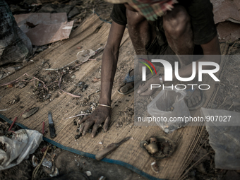 A scavenger is sorting out the metal wastes. Dhapa, Kolkata, India. January 20, 2015. *** Go to http://nurphoto.com/en/reportages/51696 to s...