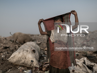 A kid scavenger is playing at Dhapa west dumping ground, Kolkata, India. January 20, 2015. *** Go to http://nurphoto.com/en/reportages/51696...