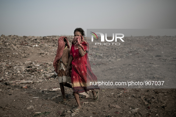 Children scavengers are hiding their faces. Dhapa, Kolkata, India. January 20, 2015. *** Go to http://nurphoto.com/en/reportages/51696 to se...