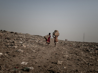 scavengers are returning from the waste dumoing ground, Dhapa, Kolkata, India. January 20, 2015. *** Go to http://nurphoto.com/en/reportages...