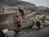 Children scavengers are passing over the boundary wall to go for waste picking in the waste mountain. Dhapa, Kolkata, India. January 20, 201...