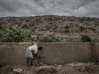 A man is building boundary wall to give the waste mountain a support as the waste overflows. Dhapa, Kolkata, India. September 12, 2015. ***...