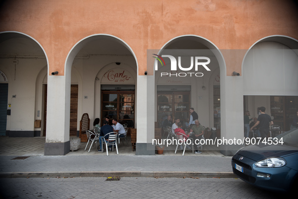 A café bar in the monumental Piazza della Repubblica, formerly Piazza della Rivoluzione, built in a characteristic D-shape, in Tresigallo, i...