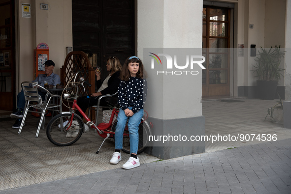 A young girl sitting on her bicycle at the café bar in the monumental Piazza della Repubblica, formerly Piazza della Rivoluzione, built in a...