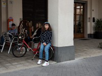 A young girl sitting on her bicycle at the café bar in the monumental Piazza della Repubblica, formerly Piazza della Rivoluzione, built in a...