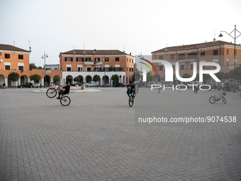 Some teenagers perform bicycle stunts in the monumental Piazza della Repubblica, formerly Piazza della Rivoluzione, built in a characteristi...