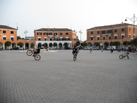 Some teenagers perform bicycle stunts in the monumental Piazza della Repubblica, formerly Piazza della Rivoluzione, built in a characteristi...